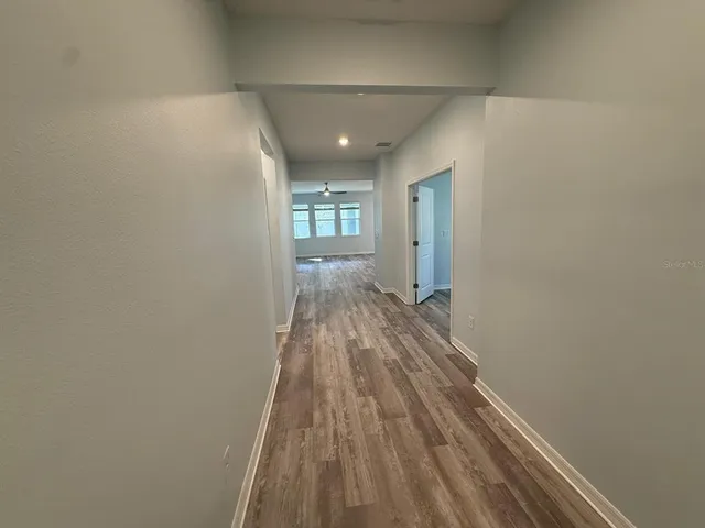 a view of a hallway with wooden floor