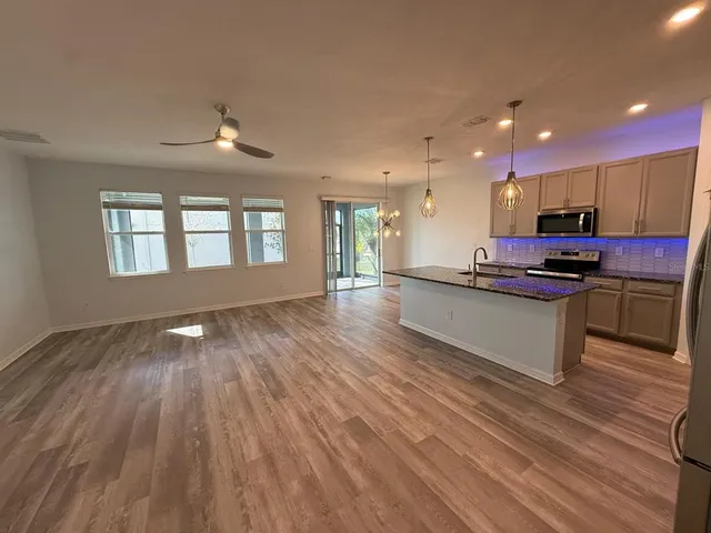 a kitchen with stainless steel appliances kitchen island granite countertop a stove a sink and a refrigerator