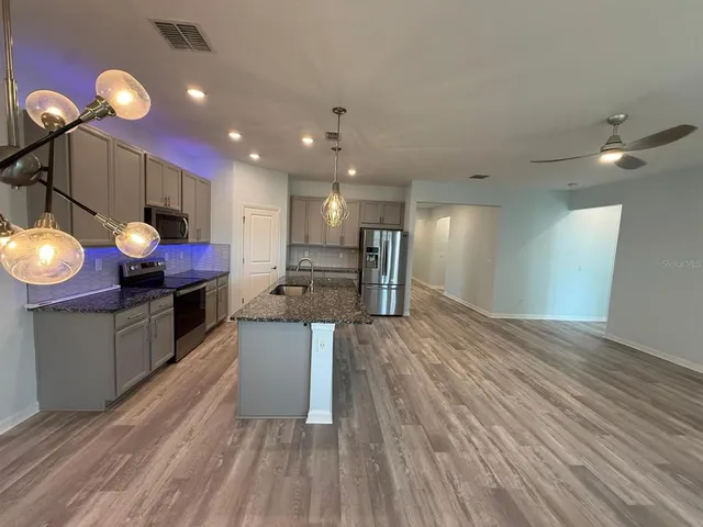 a kitchen with stainless steel appliances granite countertop a stove and cabinets