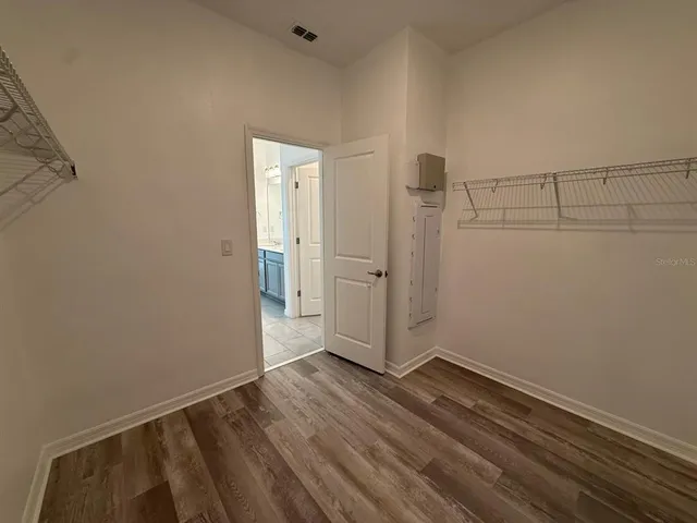 a view of an empty room with wooden floor