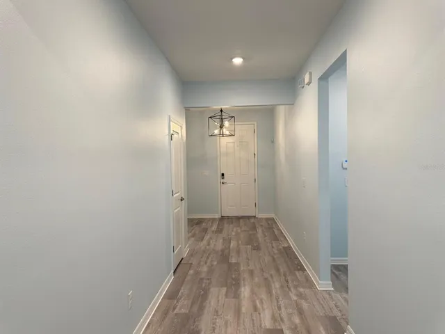 a view of a hallway with wooden floor