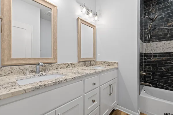 a bathroom with a granite countertop sink and a mirror