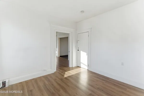 a view of a room with wooden floor and white walls