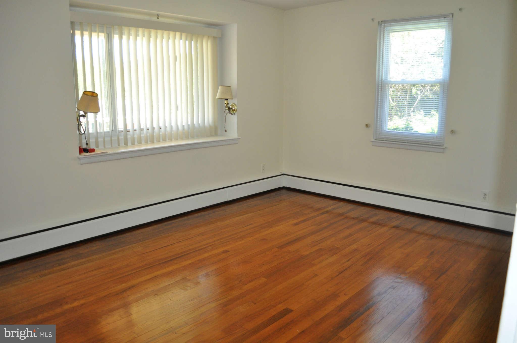 1021 Kingston Road Baltimore, MD 21208 - Photo 10 of 20 a view of an empty room with wooden floor and a window