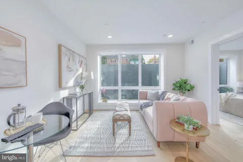 a living room with furniture potted plant and a large window