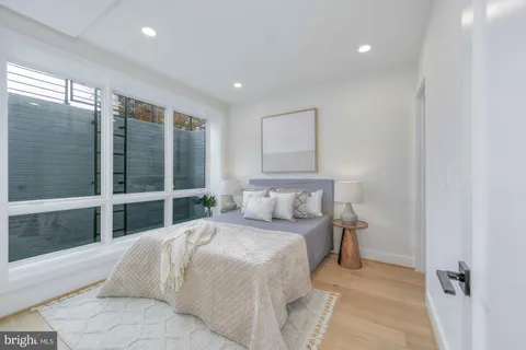 a bedroom with a bed and glass walk in closet