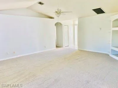 an empty room with a ceiling fan and a window
