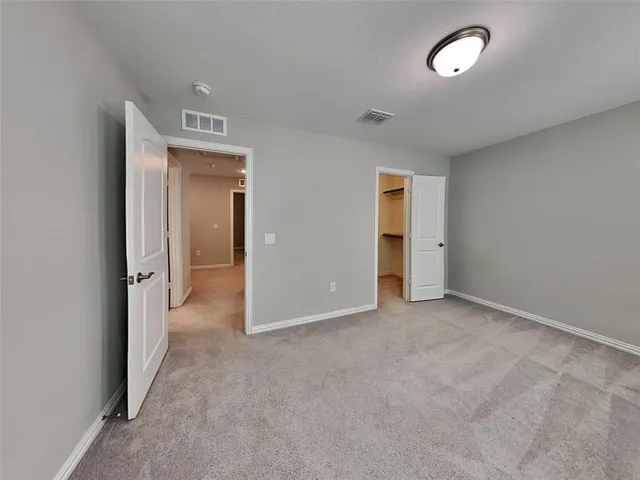 an empty room with closet and a bathroom