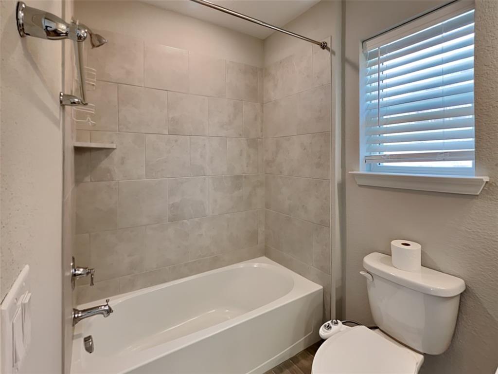 251 Novacek Street Irving, TX 75063 - Photo 16 of 18 a white bath tub sitting next to a white toilet