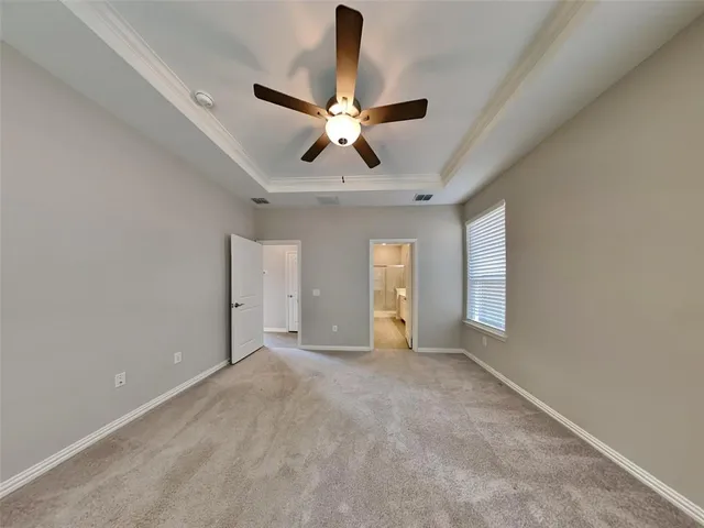 a view of an empty room and window with a chandelier fan