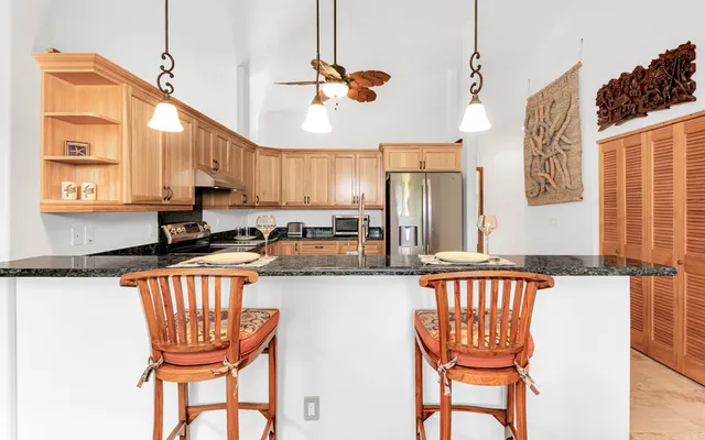 a kitchen with granite countertop a sink a counter space appliances and cabinets