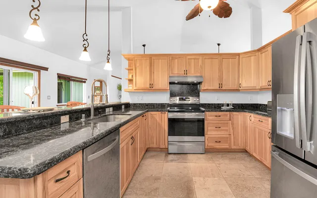 a kitchen with granite countertop a sink stainless steel appliances and cabinets