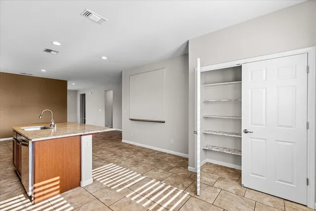 a living room with furniture a flat screen tv and a floor to ceiling window or an outdoor kitchen