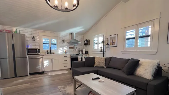 a living room with stainless steel appliances furniture and a window