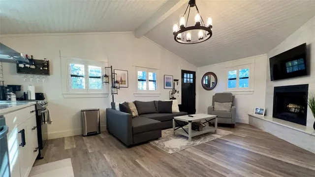 a living room with furniture a fireplace and a chandelier