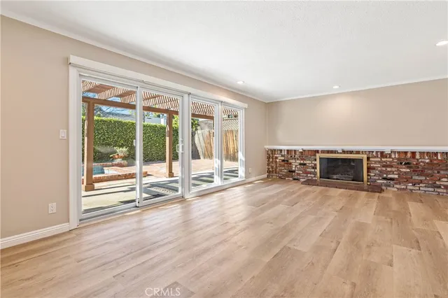 an empty room with wooden floor and fireplace