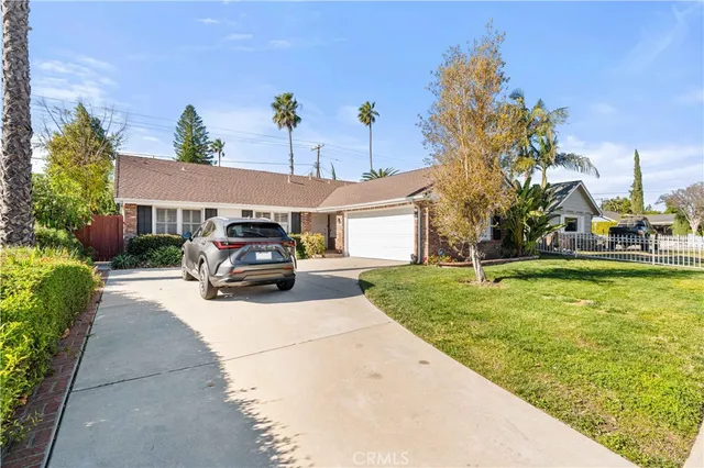 a car parked in front of a house with a yard