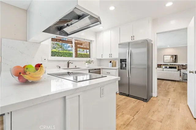 a kitchen with stainless steel appliances granite countertop a sink and a refrigerator