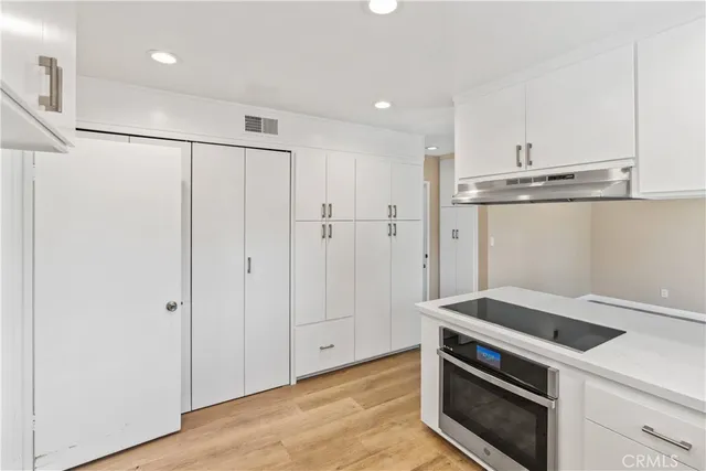 a kitchen with white cabinets and white appliances
