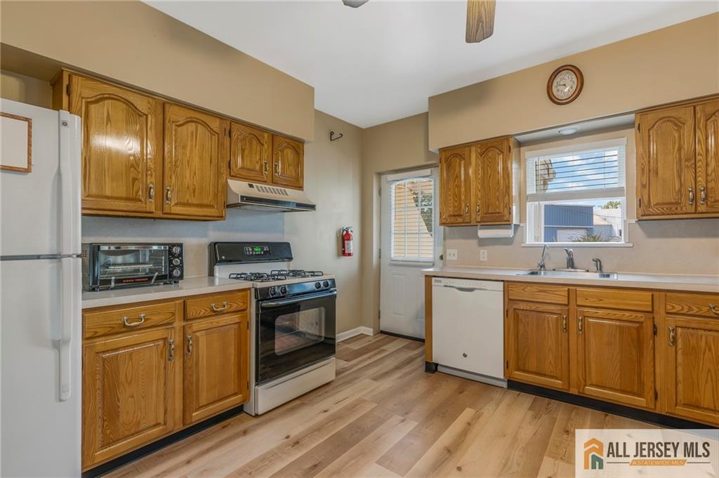 114 Runyon Avenue Middlesex, NJ 08846 - Photo 14 of 34 a kitchen with stainless steel appliances granite countertop a stove a sink and white cabinets with wooden floor