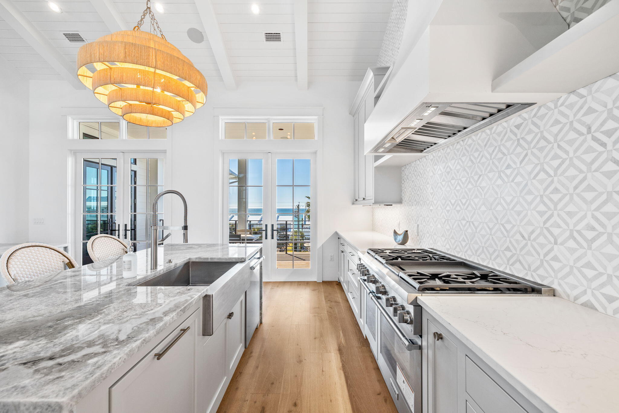 8103 East County Highway 30A Inlet Beach, FL 32461 - Photo 60 of 86 a kitchen with stainless steel appliances granite countertop a stove a sink dishwasher and white cabinets with wooden floor