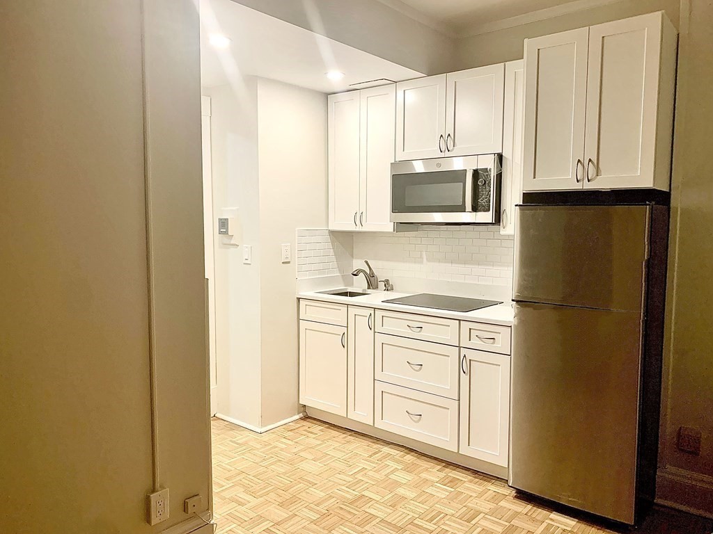 21 Beacon Street, Unit 7L Boston, MA 02108 - Photo 11 of 18 a kitchen with stainless steel appliances granite countertop a refrigerator sink and microwave