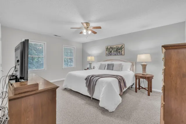 a bedroom with a large bed and a chandelier