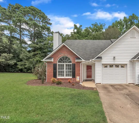 a front view of a house with a garden and yard