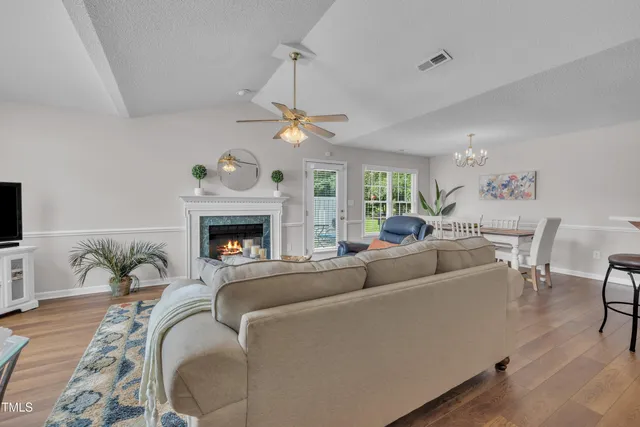 a living room with furniture a fireplace and a flat screen tv
