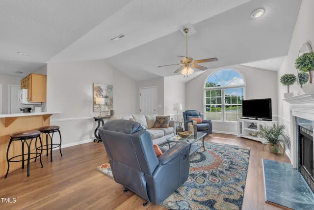 a living room with furniture a flat screen tv and a window