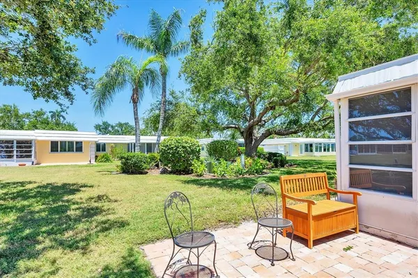 a backyard of a house with table and chairs couches and a fire pit
