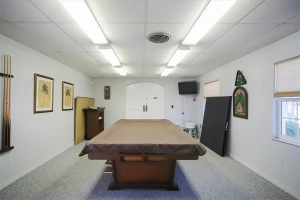 a room with pool table and windows