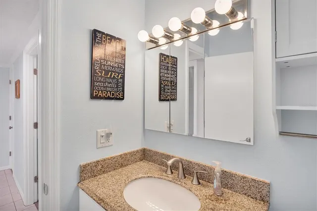 a bathroom with a granite countertop sink and a mirror