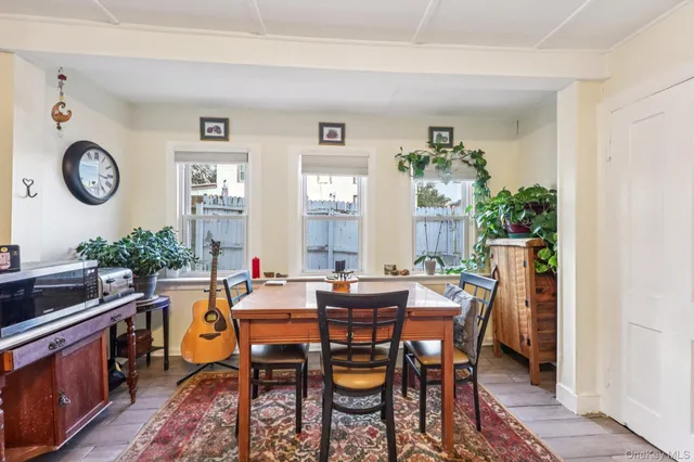 a view of a dining room and livingroom with furniture wooden floor and a rug