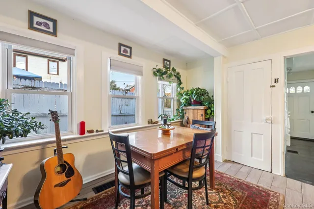 a dining room with furniture potted plants and wooden floor