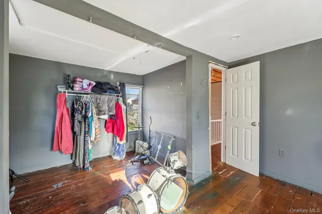 a view of a bedroom with wooden floor and a bed