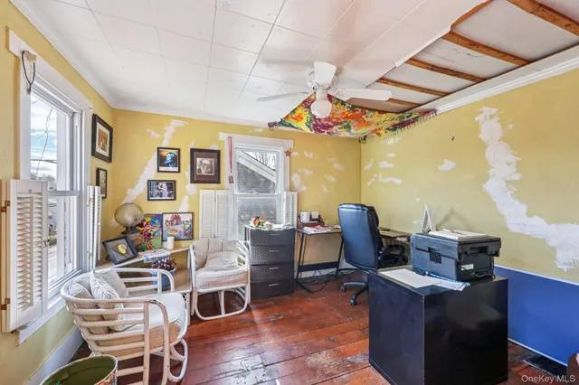 a view of a workspace with furniture and a window