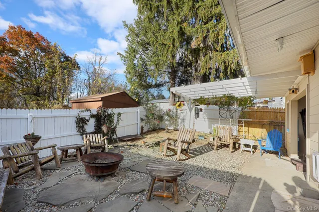 a view of the patio with dining table and chairs and potted plants