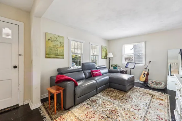 a living room with furniture a couch and two windows