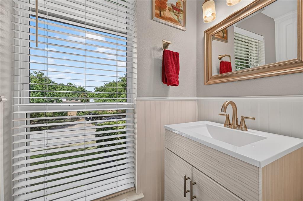 47 Bounty Road East Benbrook, TX 76132 - Photo 14 of 39 Modern vanity with a white integrated sink, gold-finish faucet, and coordinating mirror