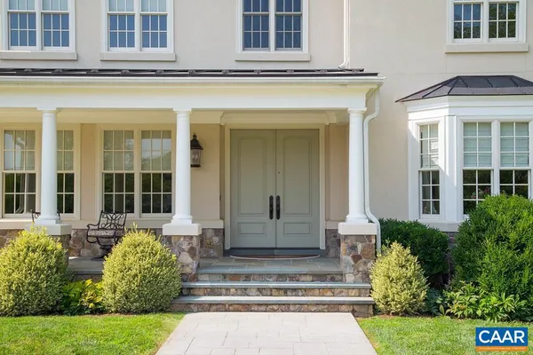 a view of a dining room and livingroom with furniture wooden floor a rug a fireplace and windows