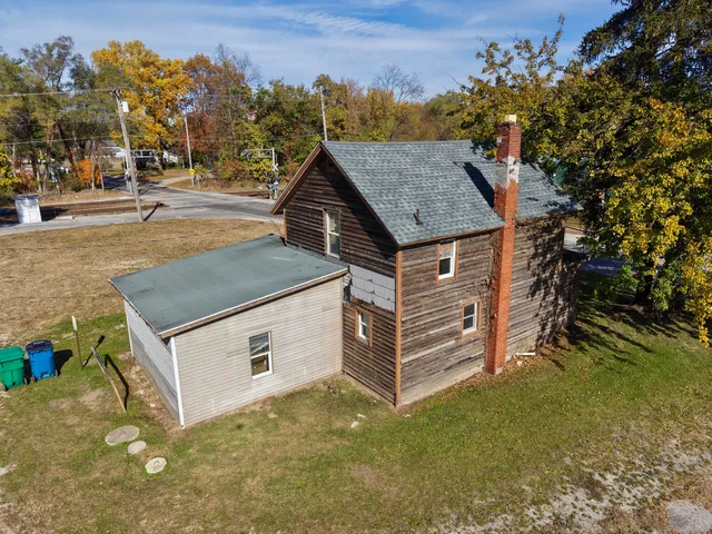 a aerial view of a house with a yard table and chairs