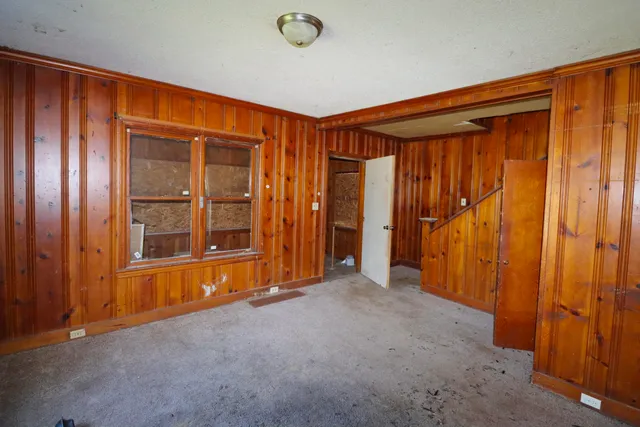 an empty room with a window and storage area