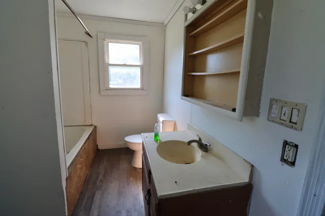 a bathroom with a sink toilet and a window