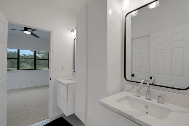 a bathroom with a granite countertop toilet sink and mirror