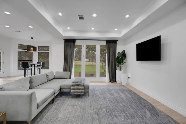 a dining room with wooden floor and windows
