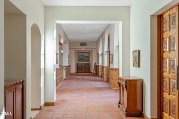 a view of a hallway with wooden floor and a bathroom