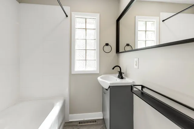 a bathroom with a sink a mirror and a bathtub