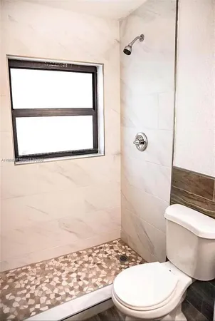 a bathroom with a toilet a sink and a window