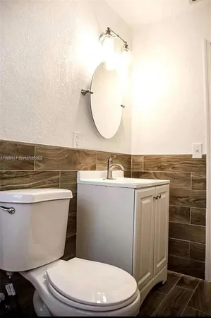 a bathroom with a toilet a sink and mirror